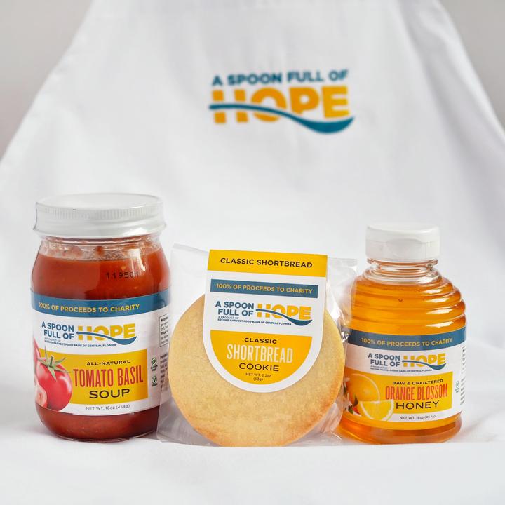 A Spoon Full of Hope Gift Box includes Tomato Basil Soup, Classic Shortbread Cookie, Honey and Logo Apron