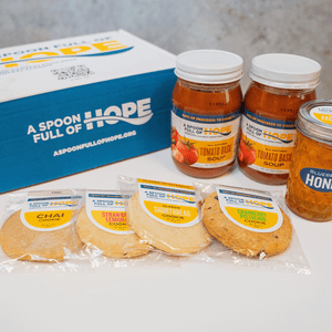 two jars of tomato basil soup, one 10oz jar of raw honey and four shortbread cookies with box from a spoon full of hope