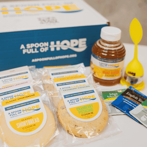 branded box from a spoon full of hope with 16oz raw honey, eight shortbread cookies, one tea steeper, and tea bags