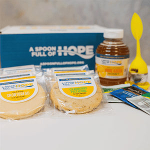 branded box from a spoon full of hope with 16oz raw honey, eight shortbread cookies, one tea steeper, and tea bags