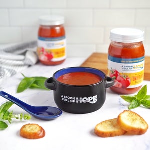 A Spoon Full of Hope Tomato Basil Soup in logo ceramic bowl with spoon