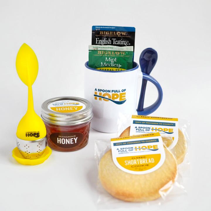 A Tea Break Full of Hope includes logo ceramic mug with spoon, 2 classic shortbread cookies, 2 teas, 5oz glass jar of mangrove honey and tea steeper